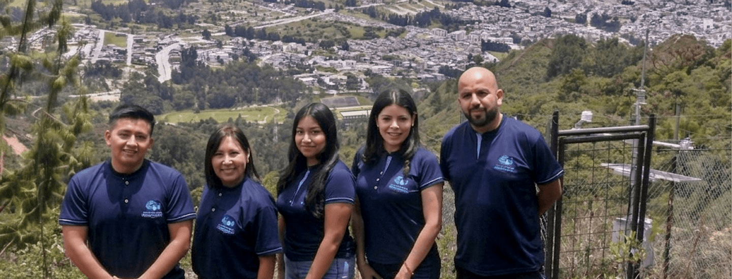 Foto del grupo de investigación en Hidroinformática de la UNL, con un paisaje montañoso de fondo y equipos de monitoreo.